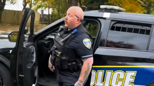 Baltimore Police Officer Robert A. Parks is pictured in a viral video before he begins driving his vehicle toward a man and crashing into a fence. (Screenshot)